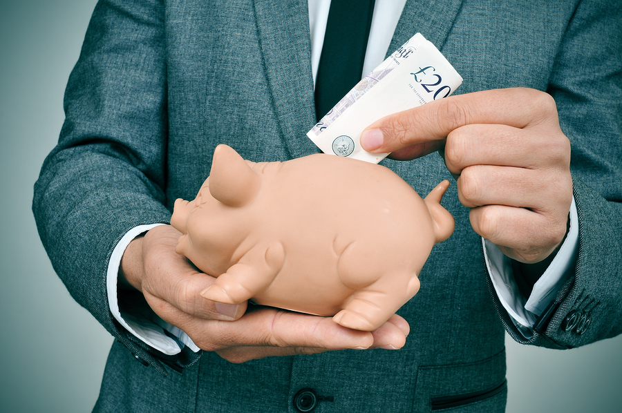 Man placing savings in piggy bank